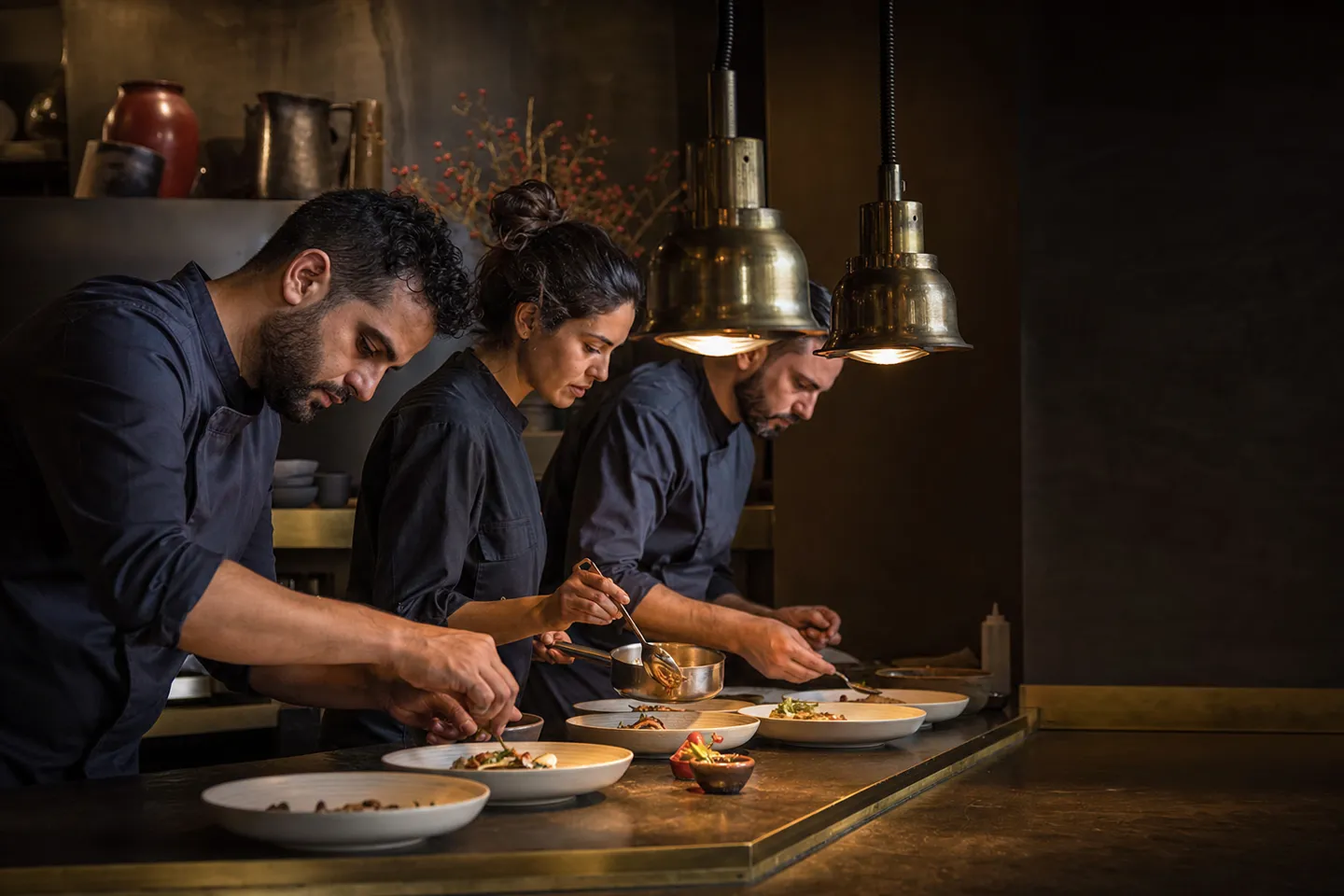 Chefs finishing plates during evening service